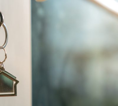 House doors with keys for new homes, new owners, buying and selling homes and real estate investments. Mortgage, rent, buy, sell, move home concept